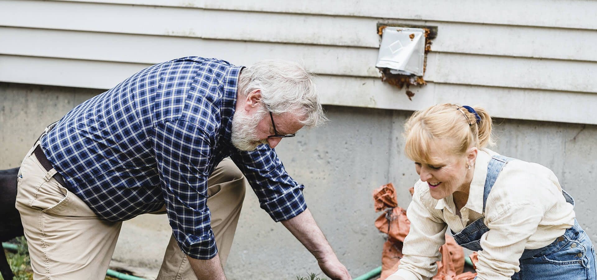 Persona mayor y cuidadora trabajando en un jardín